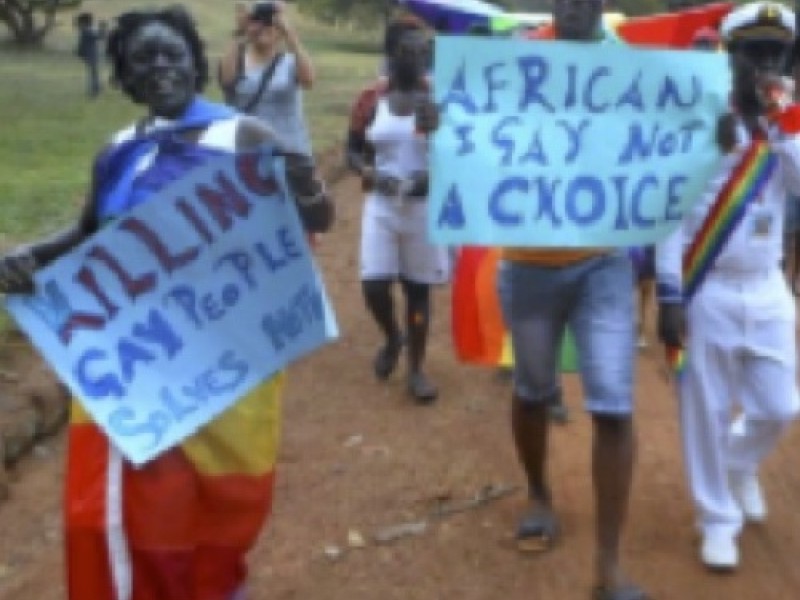 Black Gambians marching holding protest signs
