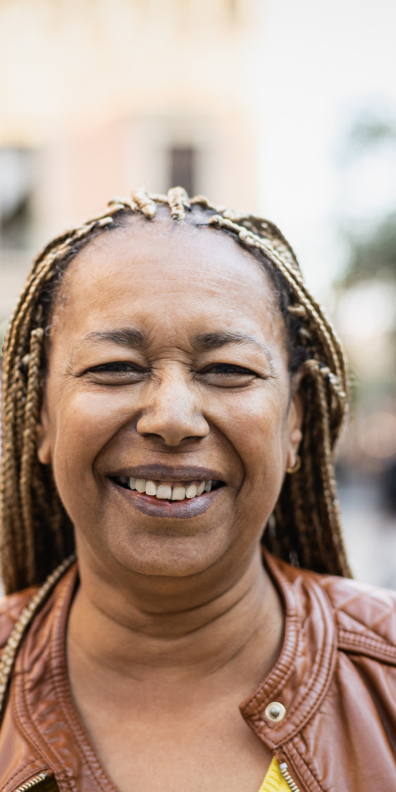 Older Black woman with braids smiling 