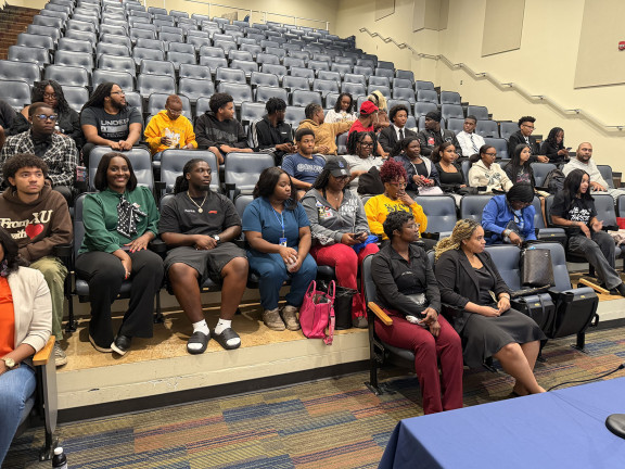 Lecture hall with young Black people sitting in the first 5 rows.