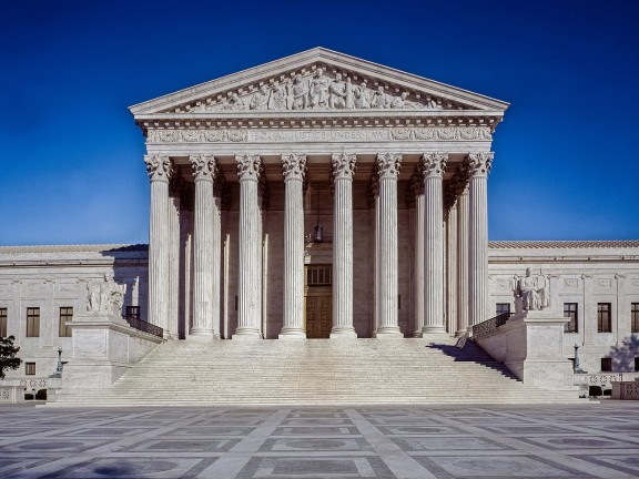 Front of US Supreme court building against blue sky