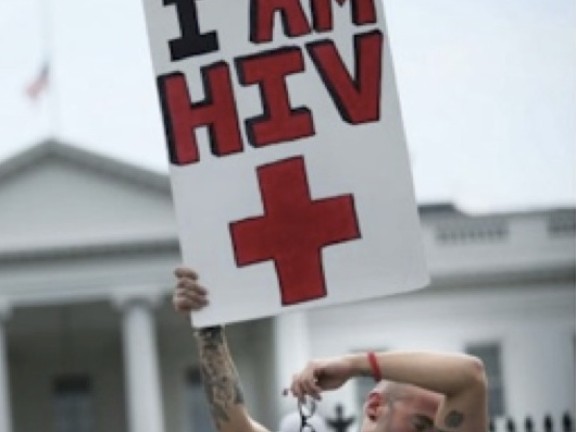 White man in front of White House holding sign reading I Am HIV+