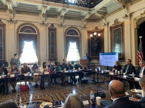 Interior of White House treaty room with 20+ people sitting around long tables