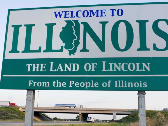Welcome to Illinois sign on side of highway with blue sky behind
