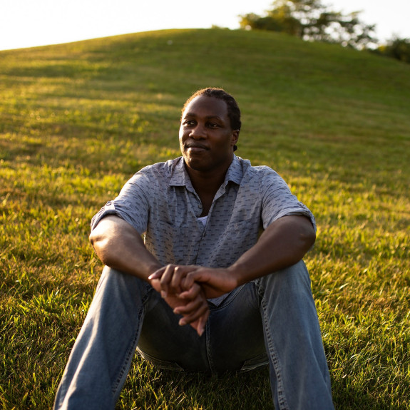 Photo of Michael Johnson sitting on grassy knoll