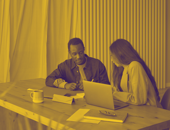 Two interns sitting at a desk with a laptop