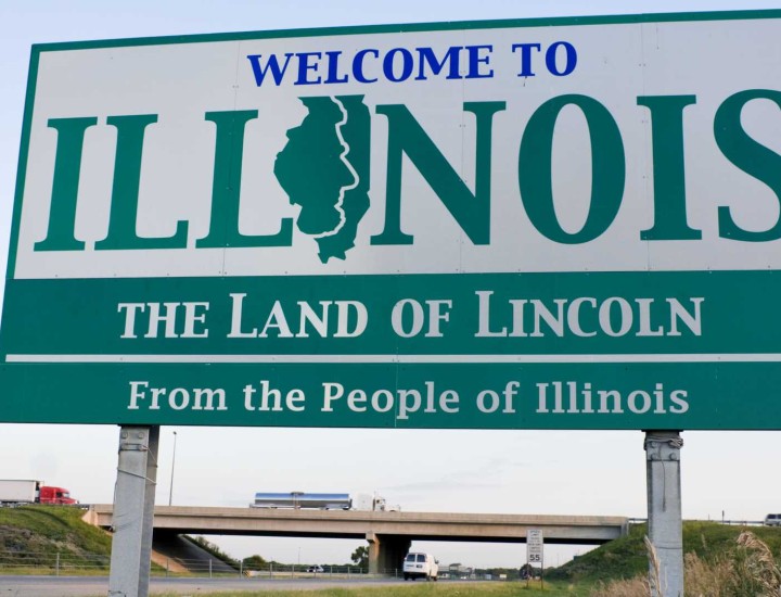 Welcome to Illinois sign on side of highway with blue sky behind