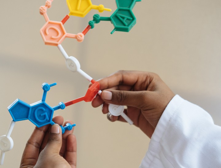 Photo of a person's hands putting together colorful toys resembling science